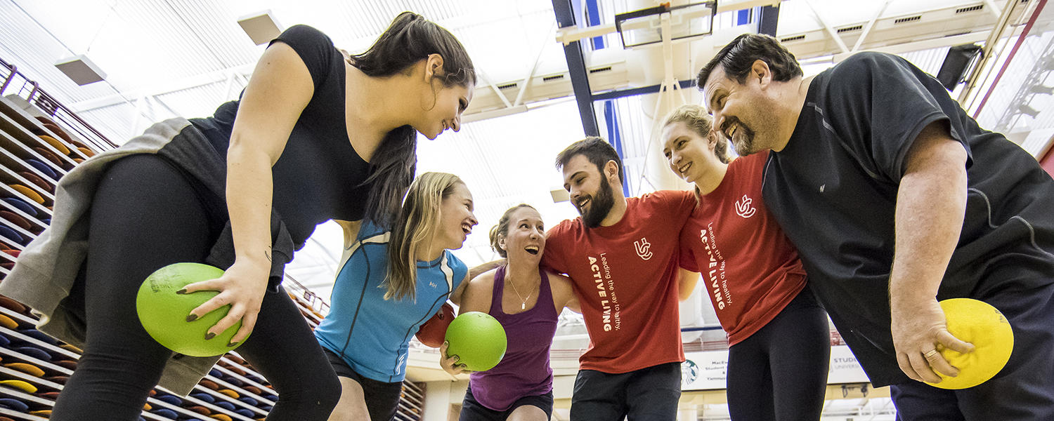 Group planning their dodgeball strategy in UCalgary gym