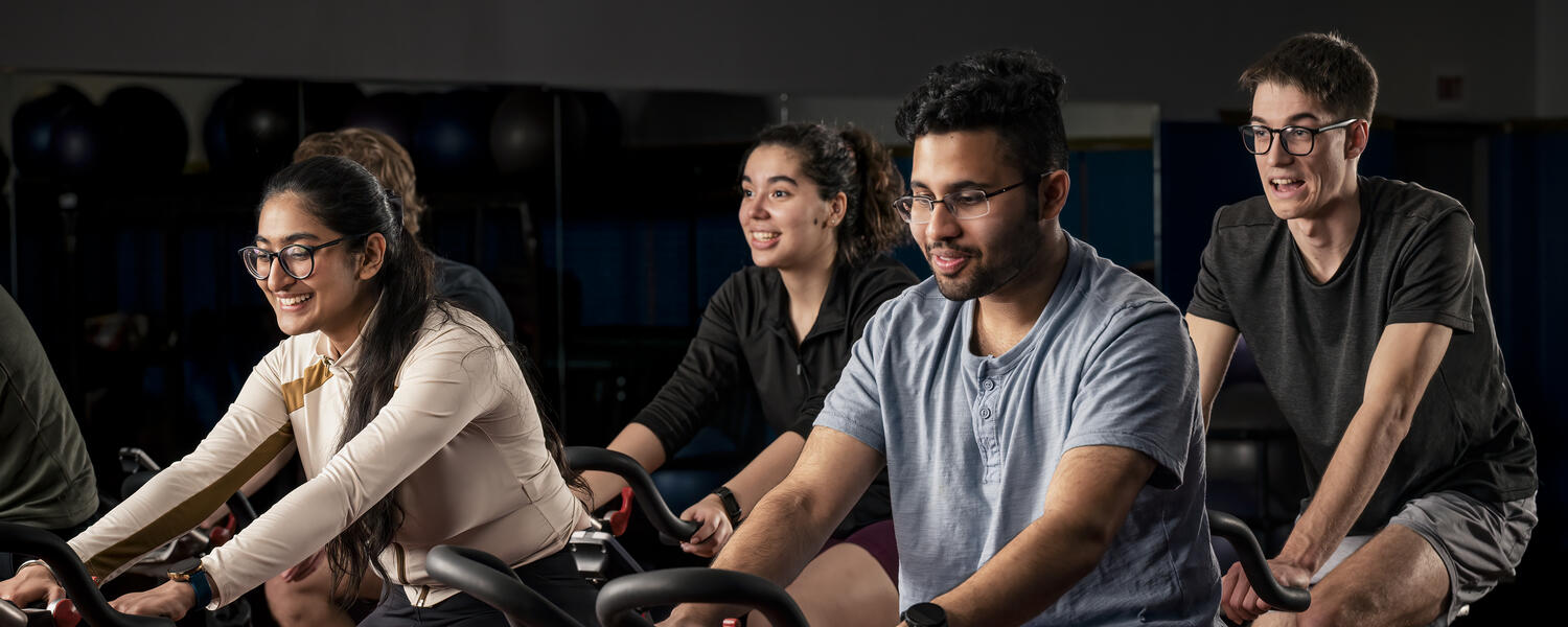 A group of people riding stationary bikes