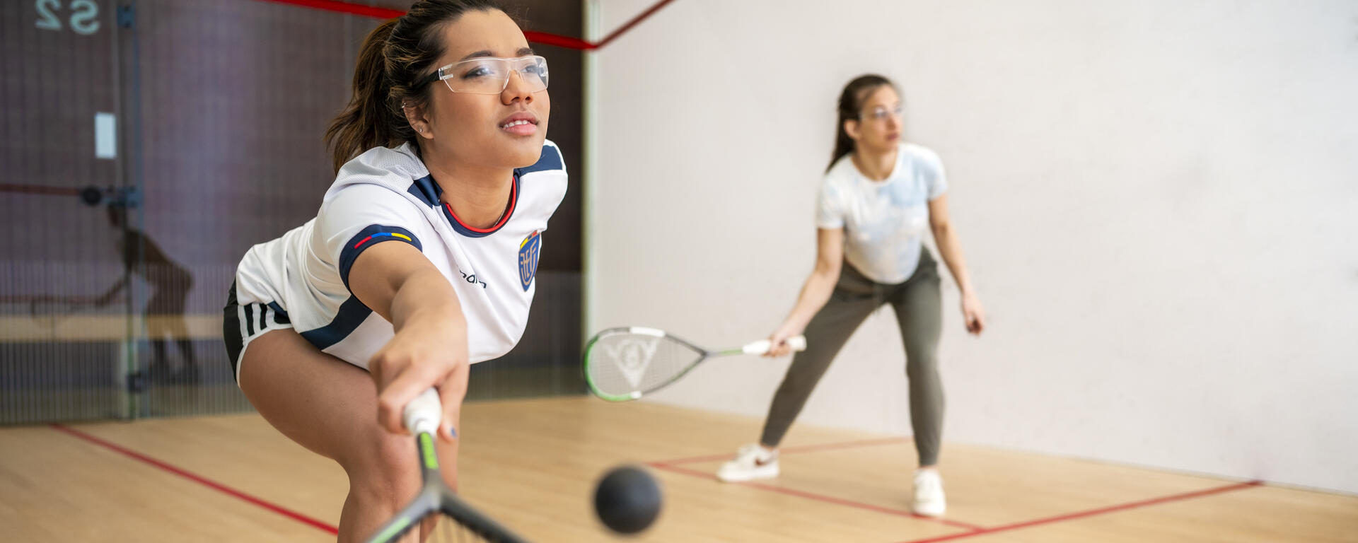 Two women playing racquet ball