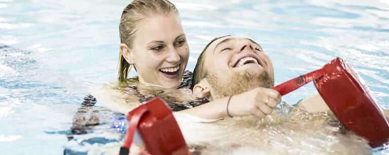 Lifeguard in the pool saving a swimmer