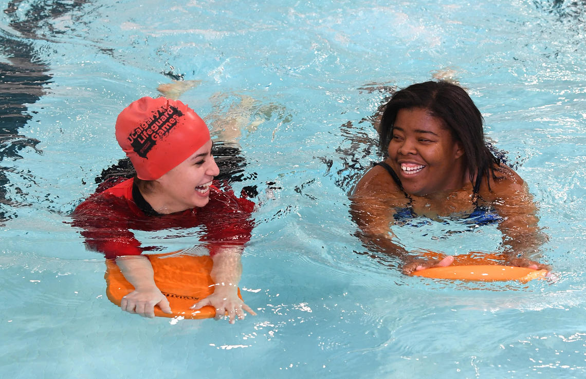 Two young women swimming with flutter boards