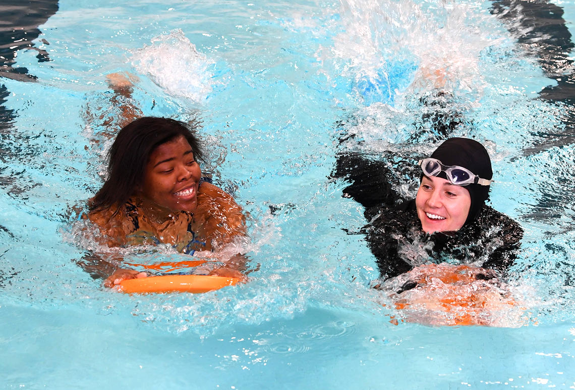 Women swimming laps with flutter board