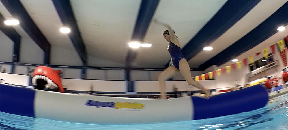 Swimmer runs across inflatable obstacle at University of Calgary pool