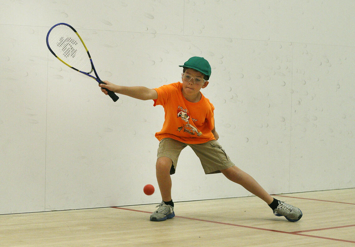 A kid playing racquet ball